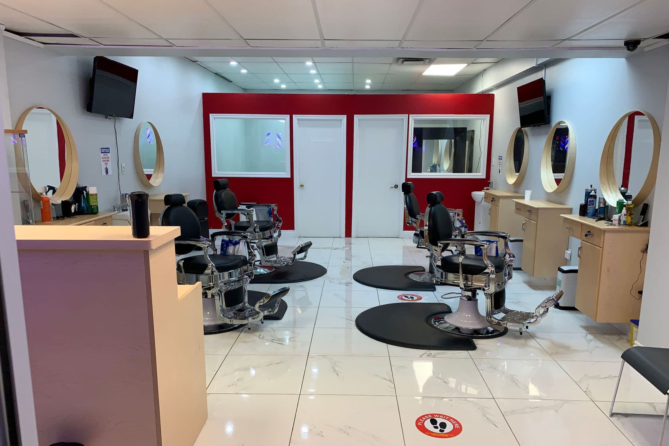 Nix Global Barbers shop interior — chrome barber chairs, gold mirrors, red accent wall